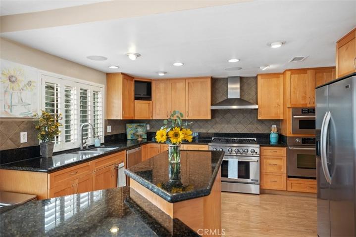 Wood cabinets, granite counter tops, stainless steal appliances, tiled back splash & recessed lighting.