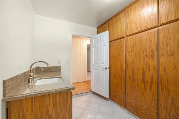 Laundry Room with Sink and granite counter. A wall of storage