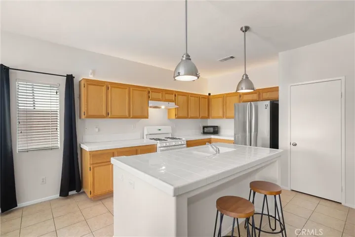 Designer light fixtures illuminate the pristine kitchen