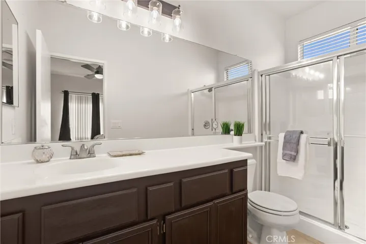 Primary bath with handsome cabinetry and enclosed glass shower