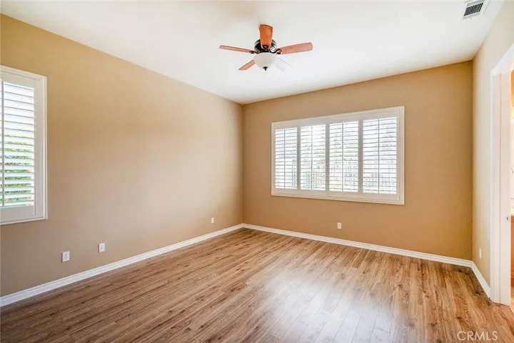 MASTER BEDROOM-LAMINATE FLOORING-LOOKS OUT OVER PATIO AND GREENBELT