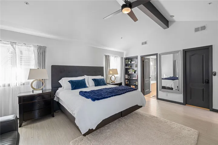 Primary bedroom with ceiling fan and lots of windows