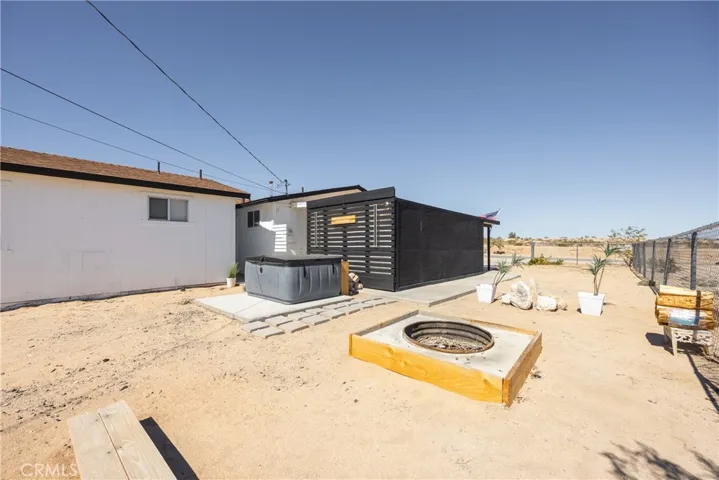 Side of home showing spa and firepit