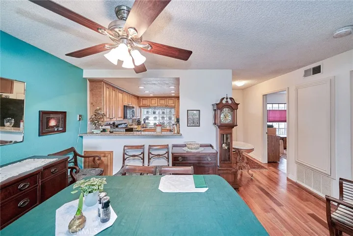 The dining area just to the other side of the breakfast bar is complete with the ceiling fan/lighting above the table.