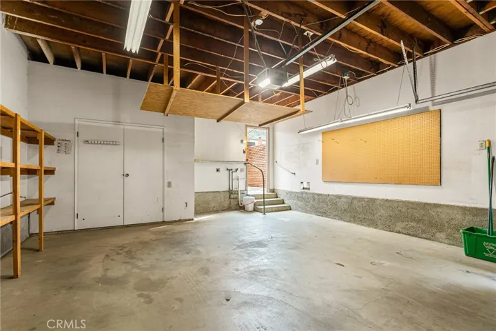 2-car garage with laundry area, storage closet and shelving.