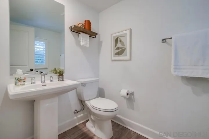 2nd floor powder room with pedestal sink, shelving, and a soft close toilet.