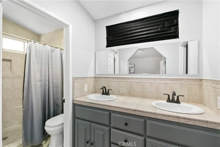 Primary bathroom with tiled shower and walk in closet