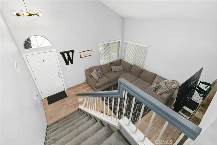 View from top of stairs to entry and living room.