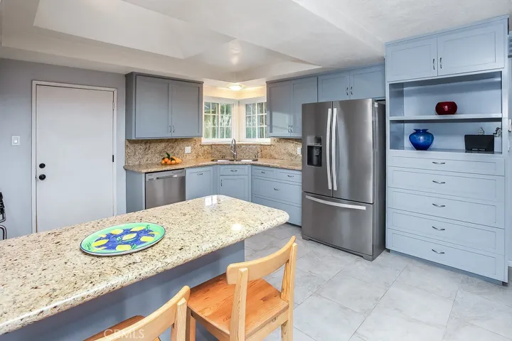 The chef in the family is going to truly appreciate the remodeled modern kitchen with its gleaming picture windows, recessed lighting, remote controlled venting skylight, custom cabinetry that reaches the ceiling, soft/self-closing drawers, granite countertops with full backsplash, durable dual basin undermount stainless steel sink, state-of-the-art stainless steel appliances which includes a Premier Pro-Series 6-burner gas range with storage compartment,  Vent-A-Hood under cabinet ventilation hood, Samsun