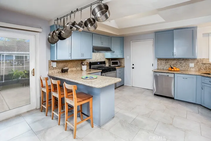 The chef in the family is going to truly appreciate the remodeled modern kitchen with its gleaming picture windows, recessed lighting, remote controlled venting skylight, custom cabinetry that reaches the ceiling, soft/self-closing drawers, granite countertops with full backsplash, durable dual basin undermount stainless steel sink, state-of-the-art stainless steel appliances which includes a Premier Pro-Series 6-burner gas range with storage compartment,  Vent-A-Hood under cabinet ventilation hood, Samsun