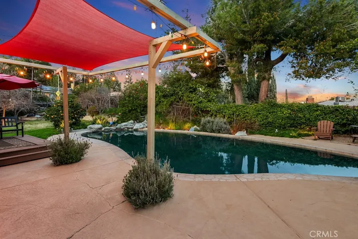 The private backyard will be a favorite entertainment destination with its sparkling in-ground pool with rock waterfall, low maintenance composite deck, sail covered pergola, special cool coating paint on the pool deck, low voltage lighting, lush green lawn, assorted fruit and citrus trees (pomegranate, fig, ruby red grapefruit, lemon, orange and Santa Rosa plum), and side yard with flagstone and relaxing fire pit.