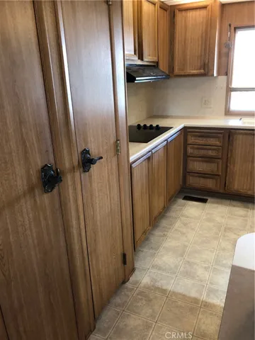 Entry to kitchen from iving room.  Pantry on left foreground