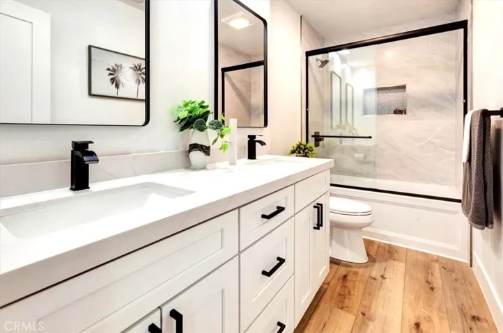 Hall Bath w/ALL NEW 66” white shaker dual vanity, Quartz countertop, acrylic tub, 30” x 60” porcelain tile shower surround, black framed glass shower enclosure, recessed lighting, lighted exhaust fan, matte black pulls, mirror, faucets, shower valve/head & accessories.