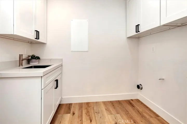 Inside laundry room w/new cabinets & utility sink.  Leviton Structured Media Center w/coax & ethernet cable, recessed lighting throughout.