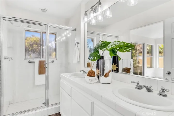 The master bath offers a step-in shower, dual vanities, designer light fixture and a brand new Toto toilet.