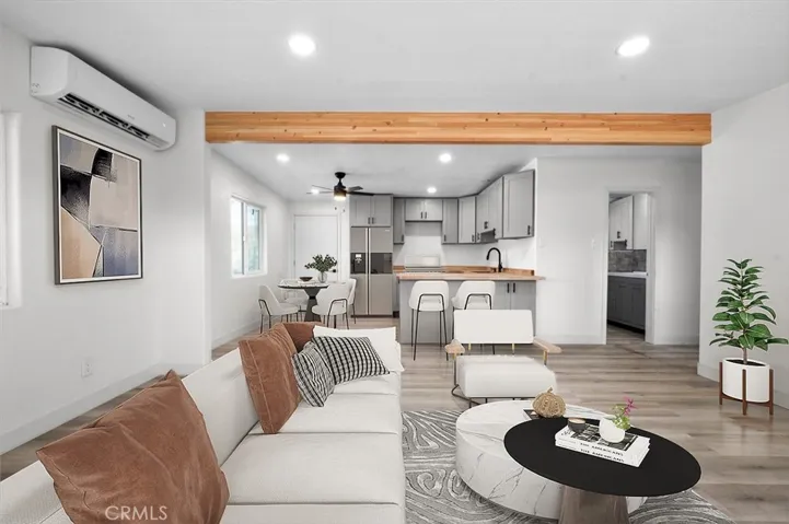 View of the living room and kitchen from the front door- image has been virtually staged