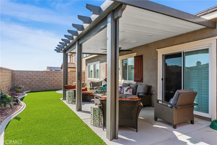 Backyard with covered patio and 1 fan with lights