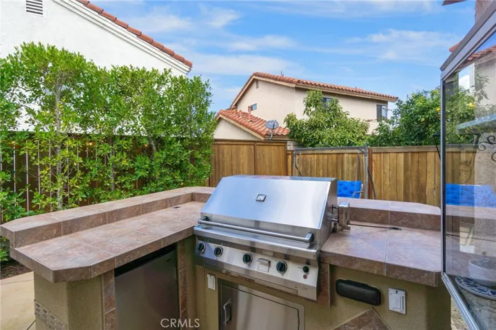 Stainless-steel, built-in BBQ with Refrigerator and extra electrical outlets for additional appliance plug-ins.