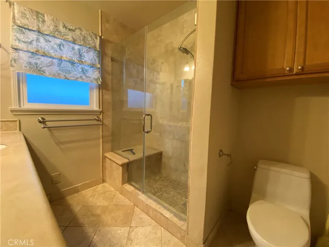 Hallway bathroom with walk in shower stall
