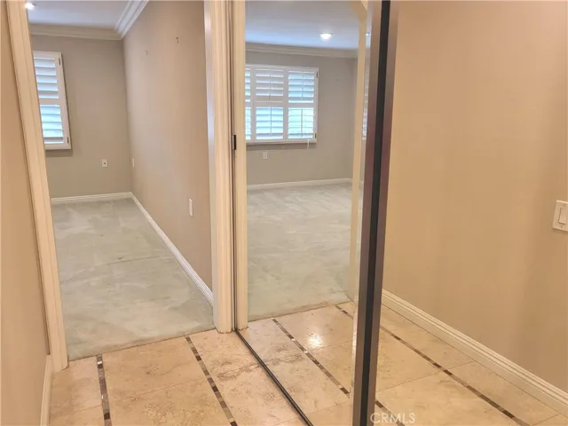 Primary suite bathroom hallway with mirrored wardrobe.