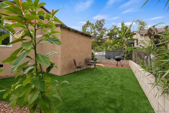 As you pass the laundry room entrance, you will then see the backyard/play area where new turf has been added.