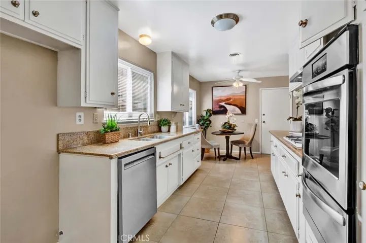 Kitchen has Newly Painted Cabinetry, Tile Flooring, and Stainless Appliances