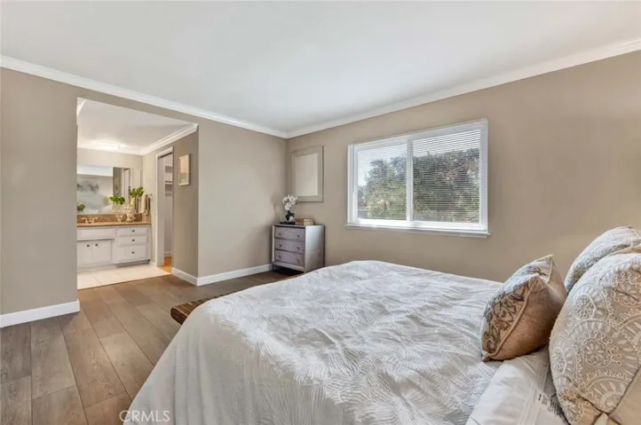 Primary Suite with Crown Molding, Wood Vinyl flooring, Dressing Area, Walk-In Closet