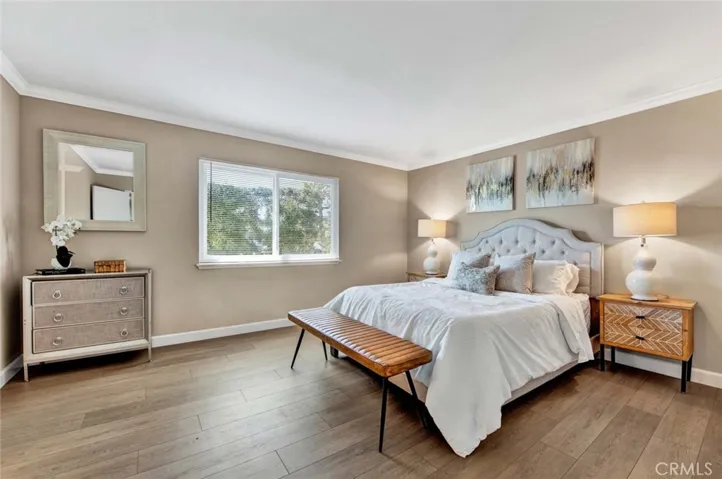 Primary Suite with Crown Molding and Wood Vinyl Flooring