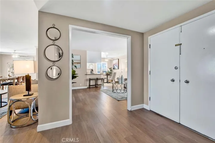 Double Entry Doors Open to Foyer and Wood Vinyl Flooring