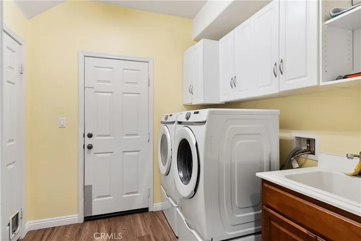 Downstairs laundry room with access to garage, linen closet, utility sink and cabinets.