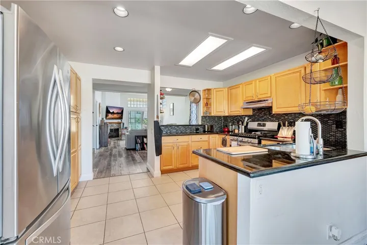 Beautiful remodeled kitchen with light cabinets contrasting dark counters & back splash.  Recessed lighting
