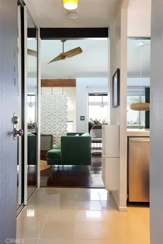Hallway with custom lighting and long reach-in mirrored wall closet