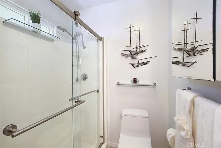 The updated bathroom with new shower doors + toilet.