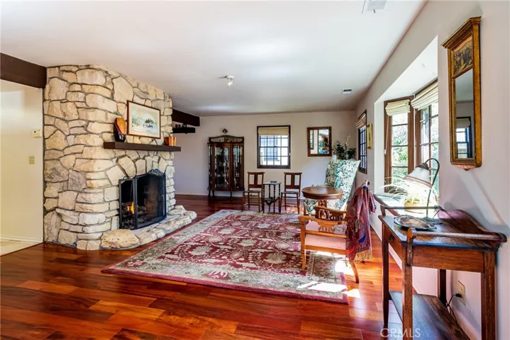 Wood flooring, stone fireplace, paned windows.