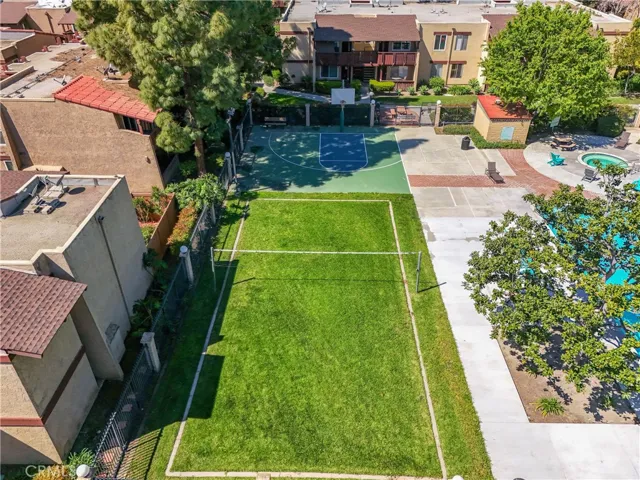 Volleyball and basketball court near the center community pool and spa along with a BBQ.