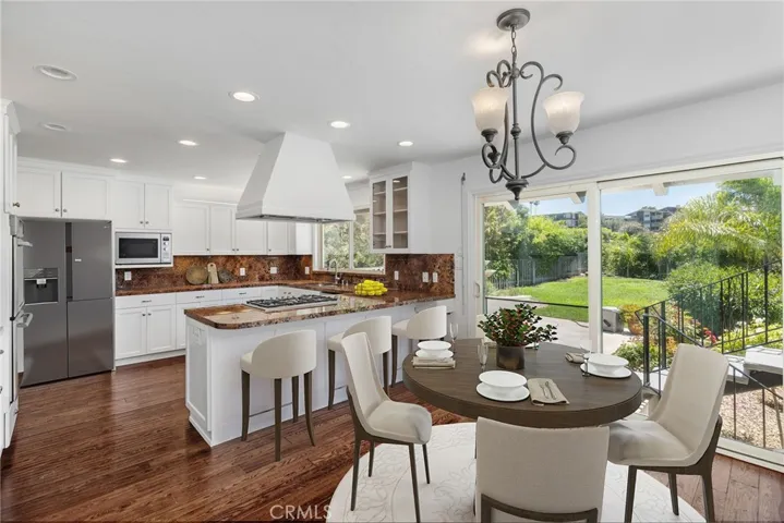 Kitchen and breakfast nook features direct access to backyard. Photo has been virtually staged.