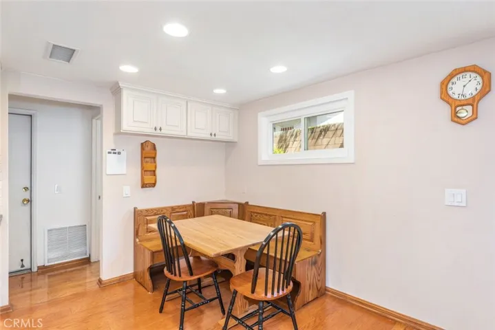 A cozy breakfast nook under bright recessed lighting, offering a comfortable space for casual dining.