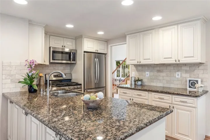 
This kitchen is a cook’s delight, with sleek stainless steel appliances, elegant granite countertops, and a welcoming island perfect for gathering and casual dining.
