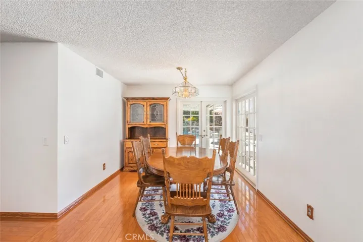 Gather for memorable meals in this formal dining room, hardwood flooring, and French doors that open to a sunny backyard.