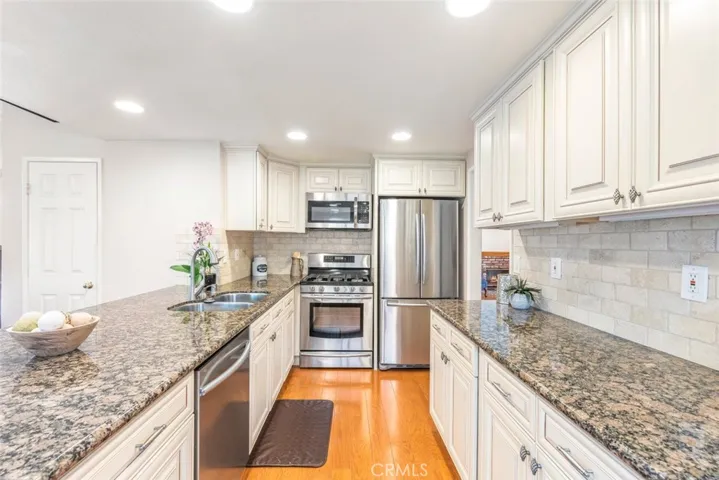 Bright and modern, this kitchen boasts gleaming granite countertops and classic cream cabinets, providing both style and functionality in the heart of the home.