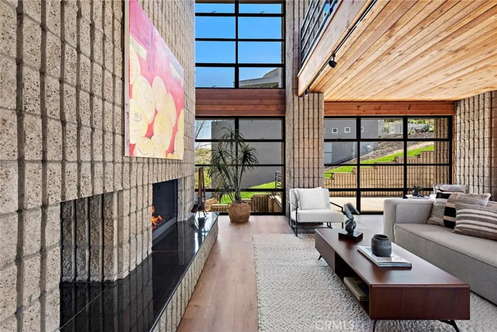 Distinct fluted concrete spanning both the exterior and interior are complemented by expansive aluminum windows and wood-paneled ceilings.