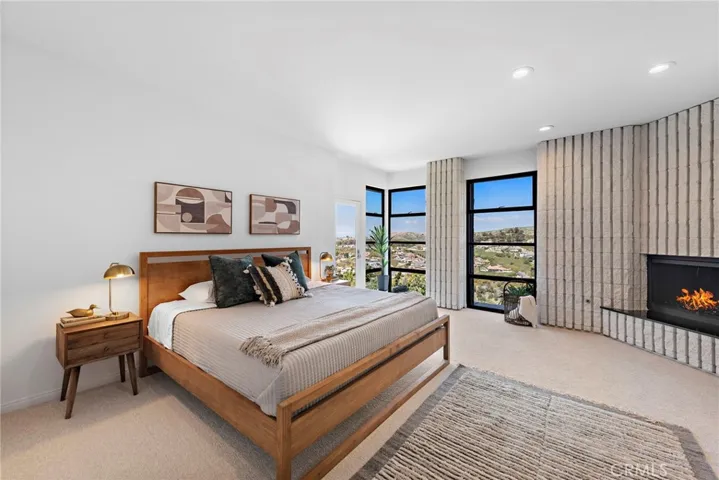 Primary Bedroom with fireplace, door leading to patio and ensuite bathroom.