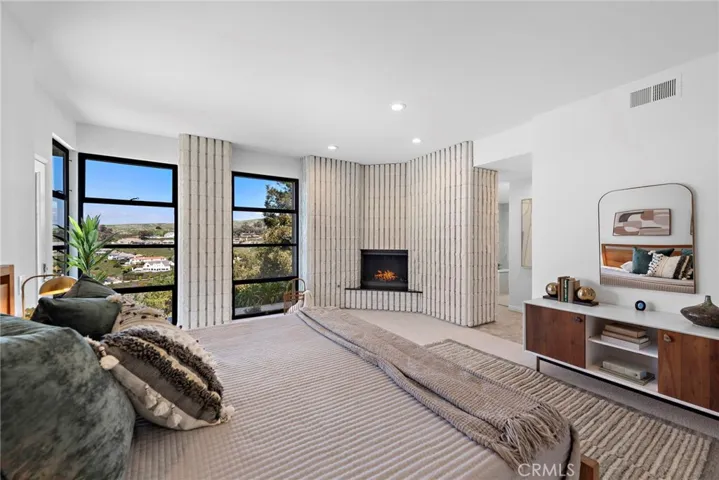 Primary Bedroom with fireplace, door leading to patio and ensuite bathroom.