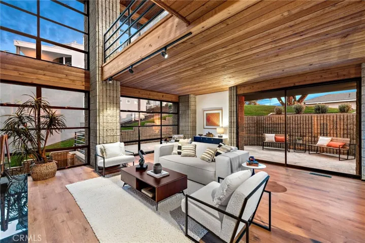 wood plank ceilings and floor to ceiling windows in the main level living room