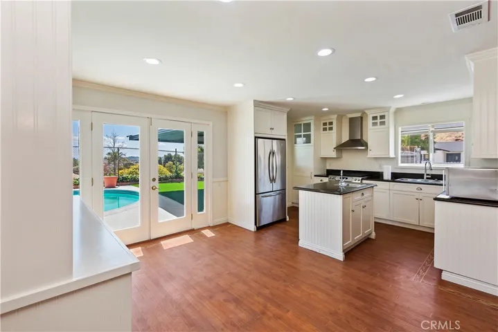 
Step into the epitome of culinary luxury as you enter this gourmet kitchen, where every detail has been meticulously crafted to inspire culinary creativity and elevate your cooking experience. Designed to seamlessly blend indoor and outdoor living, this kitchen opens onto a picturesque backyard oasis, offering breathtaking views of the pool and surrounding landscape.