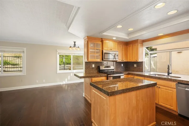 The kitchen includes newer stainless-steel appliances, walk-in pantry, recess lighting, and granite countertops