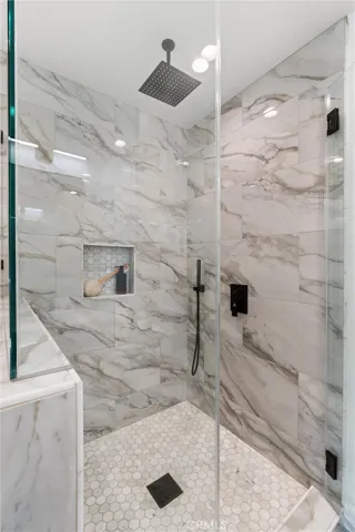 Primary ensuite multi shower head walk in shower.