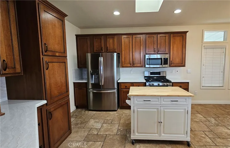 view of pantry, fridge and stove, island not included