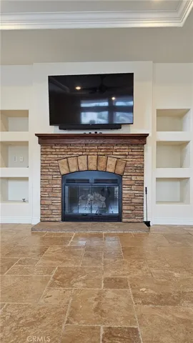 decorative fireplace, shelves, and TV