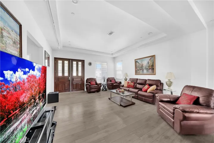Double Entry Doors to Great Room Living Room with Volume Ceilings, Recessed and Track Lighting, Dual Pane Windows, Auto (Smart) Window Blinds, and Wood Laminate Flooring